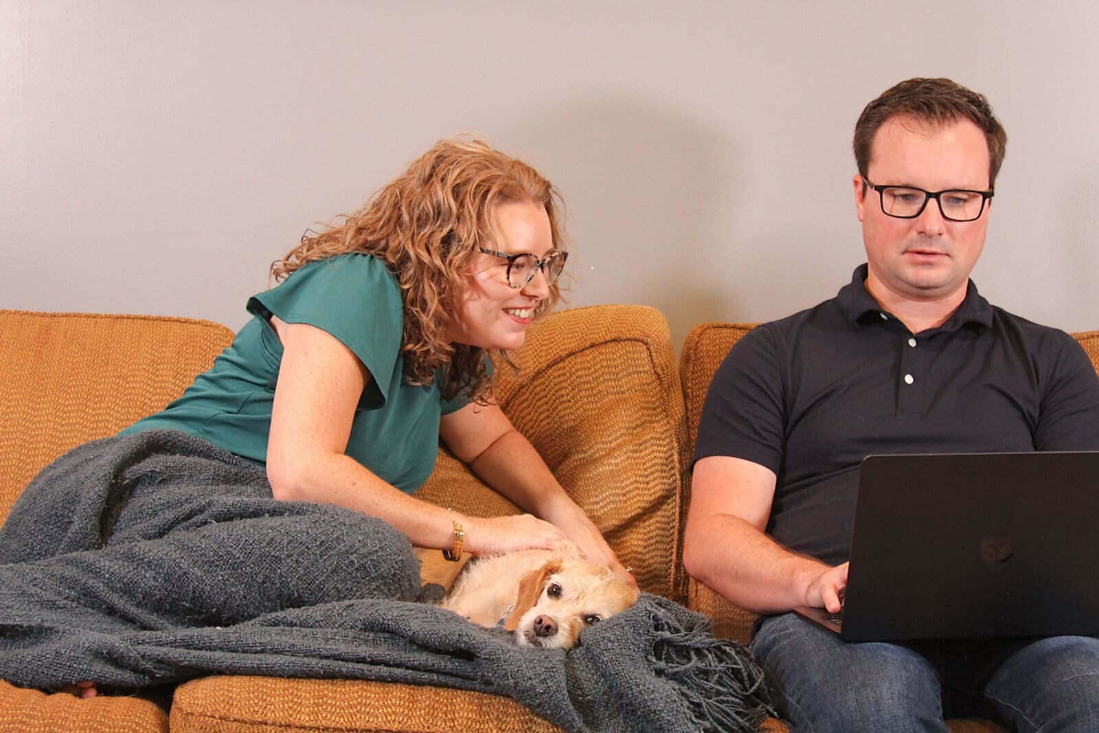Mary Beth Lynn and Robbie Lynn, systems and assistants experts for travel advisors, working from their gold couch.